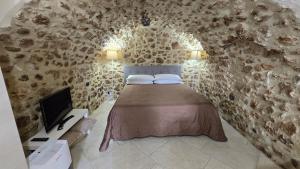 a bedroom with a bed in a stone wall at Il Grottino in Pescasseroli