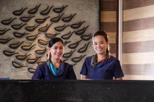 two young girls are standing behind a counter at Panglao Homes Resort & Villas in Panglao Island