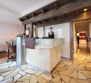 a man standing behind a counter in a restaurant at Hotel Menge "An der Schlacht" in Arnsberg