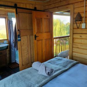 a bedroom with a bed in a wooden cabin at The Fat Mulberry Guest Farm in Fouriesburg