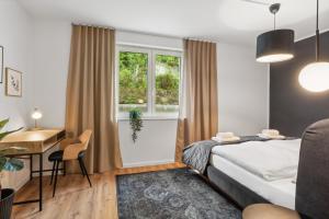 a bedroom with a bed and a desk and a window at Stylisches Apartment mit Terrasse & kostenlosem Parkplatz Beste Lage in Bielefeld in Bielefeld