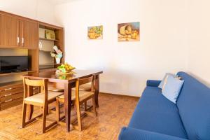 a living room with a table and a blue couch at Dimora del Pittore, Usellus in Usellus