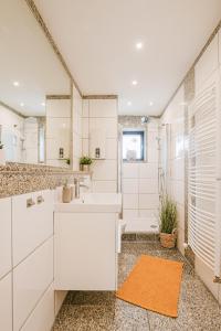 a white bathroom with a sink and a shower at BW5 - Stilvolle Loftwohnung - 4 Zimmer - 115 m2 - Klimaanlage in Mülheim an der Ruhr