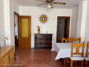 a dining room with a table and a ceiling fan at Piso en la Cala de la tía Antonia in San Juan de los Terreros