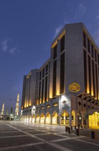 a large building with a clock on the side of it at The Oberoi Madina المدينة أوبروي in Al Madinah