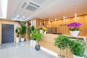 a lobby with potted plants and a reception counter at Mokpo Brown Dot Hotel Namak in Mokpo +76 photos