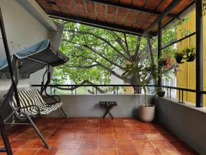 a balcony with a chair and a tree at Idam Na Mama - Luxury Homestay by HomeSlice in Bangalore