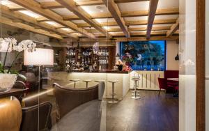 un bar in un ristorante con tavolo e sedie di Post Hotel - Tradition & Lifestyle Adults Only a San Candido