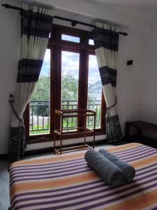 a bedroom with a bed and a large window at Kelum Homestay in Kandy