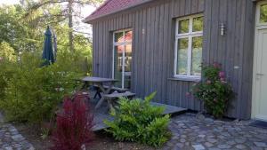 a wooden cabin with a picnic table and a window at Landhaus Alte Schule nahe Ostseebad Rerik XL in Alt Bukow