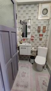Un baño con inodoro, lavabo y puerta. en Nur home 2, en Estambul 22 fotos más