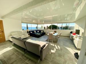 un grand salon avec un canapé et une table dans l'établissement VILLA SUPERBE VUE MER SUR LA BAIE DE BANDOL , 200 m des PLAGES, à Sanary-sur-Mer