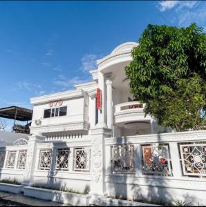 a white building with a tree in front of it at Taj Residence Syariah in Medan