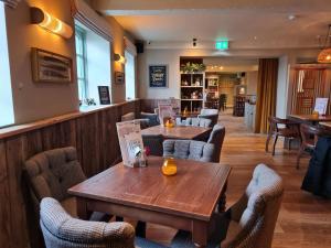 un ristorante con due tavoli e sedie in legno di The Stork Hotel a Lancaster