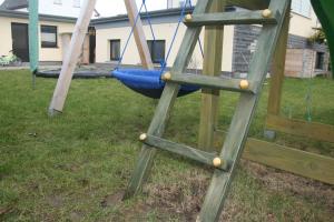 Una escalera de madera con un columpio en un patio. en Urlaub beim Reriker Ostseefischer, en Rerik