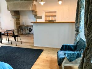 a living room with a couch and a kitchen at Manoir Les Vieilles Aires in Montauban-de-Bretagne