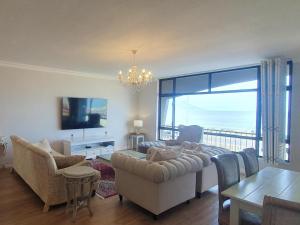 a living room with a view of the ocean at Bloubergstrand Beachfront Apartment Witsand 101 Tablemountain and ocean views in Cape Town