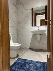 a bathroom with a toilet and a sink and a mirror at Luxury Furnished Appartments in Abidjan +96 photos