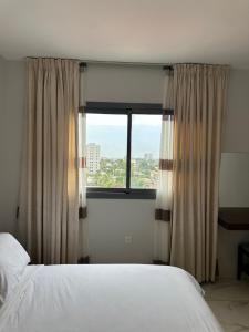 a bedroom with a bed and a large window at Luxury Furnished Appartments in Abidjan
