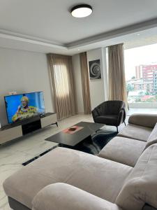 a living room with a couch and a flat screen tv at Luxury Furnished Appartments in Abidjan