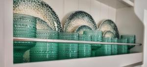 a bunch of green bowls on a shelf at Diana's Luxury Suites in Kithnos