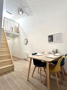 a dining room with a wooden table and chairs at 735 Cosy studio mezzanine près de Paris et métro in Bagnolet