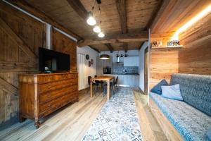 Una sala de estar con un sofá, un televisor y una mesa. en Casa Vacanza Vecchia Mura, en Mura
