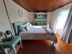 a bedroom with a bed and a table and a window at Helpmekaar Farm in Kareedouw
