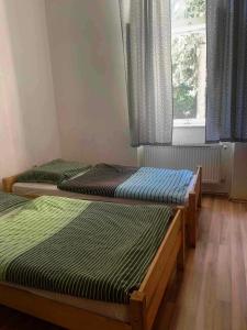 due letti singoli in una stanza con finestra di Penzión Sandrik a Hodruša