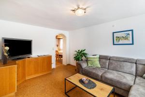 a living room with a couch and a flat screen tv at Ferienhaus Albert in Bühl