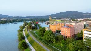 Una vista aérea de una ciudad con un río y edificios. en Trans World Hotel Donauwelle, en Linz