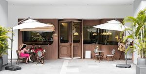 吉隆坡Skyscraper 65 KL Highest Outdoor Bathtub Luxury Lavish Designer Suite Penthouse Lv65的两人坐在餐厅前面的桌子上