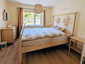 um quarto com uma cama de madeira e uma janela em Mountain View Cottage em Cloontyprughlish