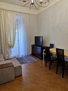 a living room with a table and a television at Затишна квартира на Майдані Незалежності in Kyiv