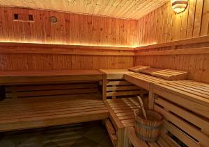 a wooden sauna with benches and a bucket in it at Waldhotel Wandlitz in Wandlitz +4 photos