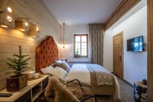 a bedroom with a large bed in a room with wooden walls at Niedźwiedzia Residence Garden & Sauna in Poronin