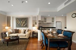 a kitchen and living room with a table and a couch at Grande Centre Point Hotel Ratchadamri Bangkok in Bangkok