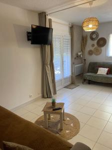 ein Wohnzimmer mit einer Couch und einem Fernseher an der Wand in der Unterkunft La Bandolaise, studio 25m2 in Bandol + 4 Fotos