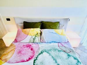 a bed with colorful blankets and pillows on it at I piedi nell'acqua in Finale Ligure