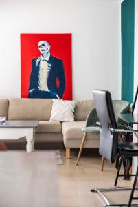 a living room with a couch and a painting of a man at Haus 6 Pers mit Garten 15 min zur Messe Düsseldorf in Krefeld