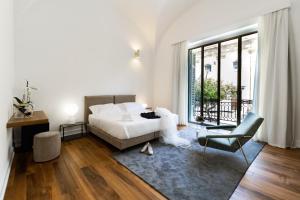 una camera da letto bianca con un letto e una sedia di Dome Hotel a Marsala