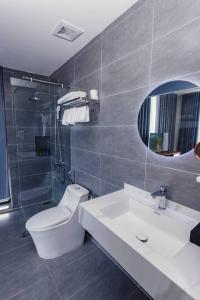 a bathroom with a toilet and a sink and a mirror at Flamingo Hải Tiến - Lavender Villa 6 phòng ngủ in Nam Khê