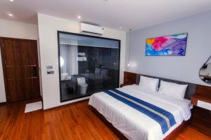 a bedroom with a large bed and a bathroom at Flamingo Hải Tiến - Lavender Villa 6 phòng ngủ in Nam Khê
