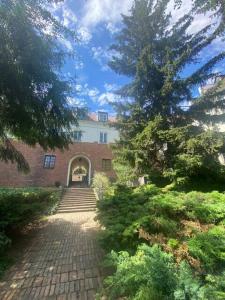 Un edificio de ladrillo con una escalera que conduce a un edificio con árboles. en Royal Castle appartment 2 rooms and kitchen 55sqm, en Varsovia