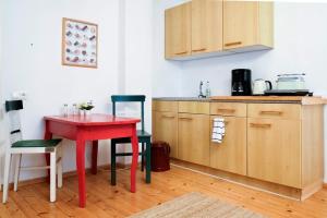 una pequeña cocina con mesa roja y sillas en Ferienwohnung am Land mit Whirlpool, en Eggersdorf bei Graz