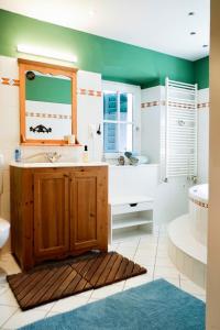 Un baño con lavabo, bañera y espejo. en Ferienwohnung am Land mit Whirlpool, en Eggersdorf bei Graz