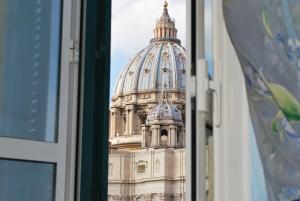 a view of a domed building through a window at San Peter's Corner in Rome