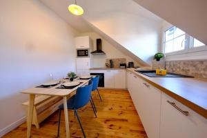 a kitchen with a table and some blue chairs at Rouen - Bienvenue chez Ninon in Le Petit-Quevilly