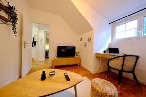 a living room with a table and a television at Rouen - Bienvenue chez Ninon in Le Petit-Quevilly
