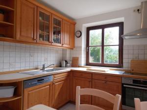 a kitchen with wooden cabinets and a sink and a window at Familienfreundliche Fewo mit Garten in Cadolzburg